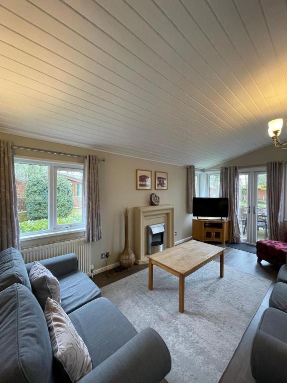 a living room with a couch and a table at Churchill Lodge in Kingham