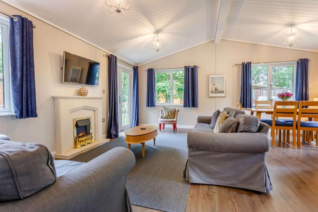 a living room with two couches and a fireplace at Churchill Lodge in Kingham