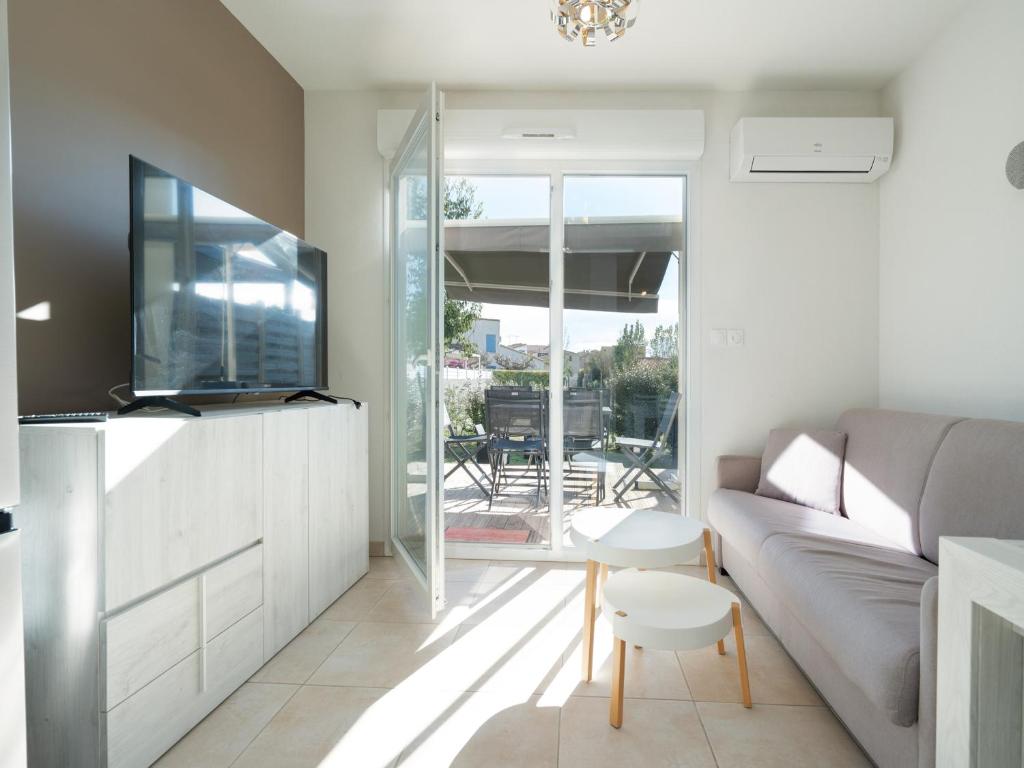 a living room with a couch and a tv at La Dune 32 - Villa 2P4 in Sérignan