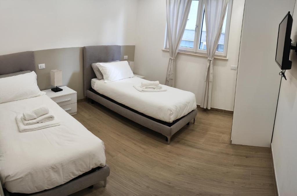 Un dormitorio con dos camas y una ventana. en Appartamento Filo, en Castel di Sangro