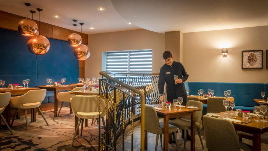 a man standing in a dining room with tables at Clayton Hotel & Leisure Club Sligo in Sligo