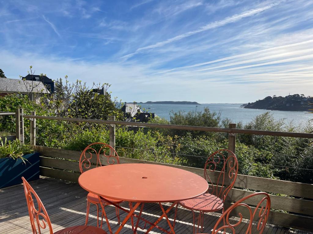 une table et des chaises sur une terrasse avec vue sur l'eau dans l'établissement Appartement BELLE VUE MER sur la baie de Trestraou à PERROS-GUIREC - Réf 913, à Perros-Guirec