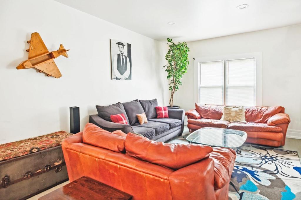 a living room with two couches and a table at 4BR Gem in Detroit North End Downtown Nearby in Detroit