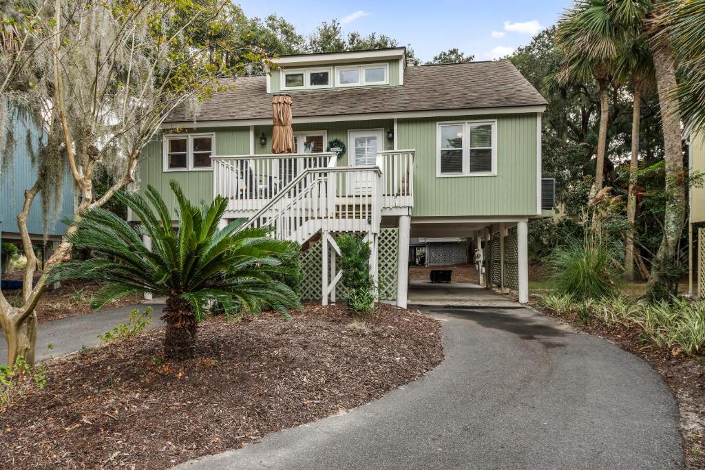 a green house with a white staircase in front of it at 515 Tarpon Pond Cottage in Seabrook Island