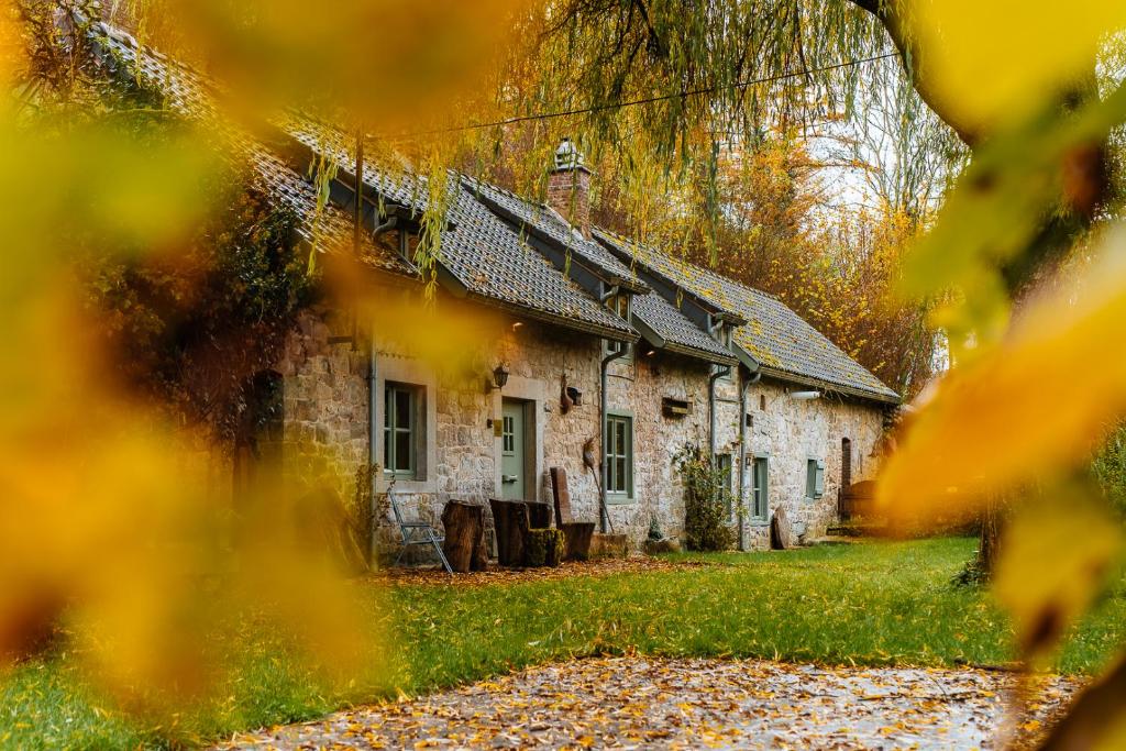 an old stone house in the middle of a yard at La Petite Foret 17th Cent Cottage Near Durbuy in Clavier