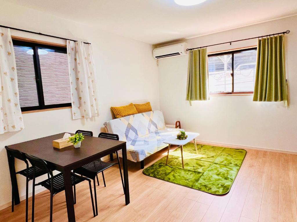 a living room with a table and a couch at Hana Home - New Cozy House with 4 bedrooms - 10min from Umeda in Osaka