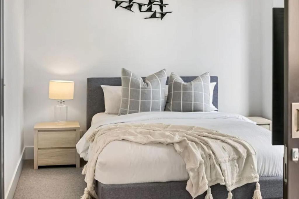 una camera da letto con un grande letto con cuscini bianchi e grigi di Parkvue 11 What a Spot a Mornington