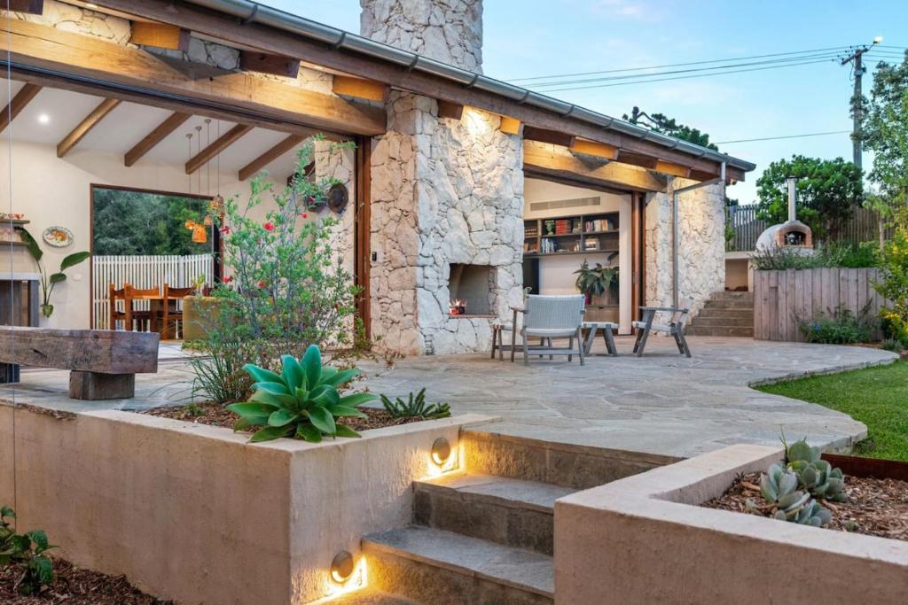 a patio with a stone fireplace in a backyard at LUXE POINT in Blairgowrie