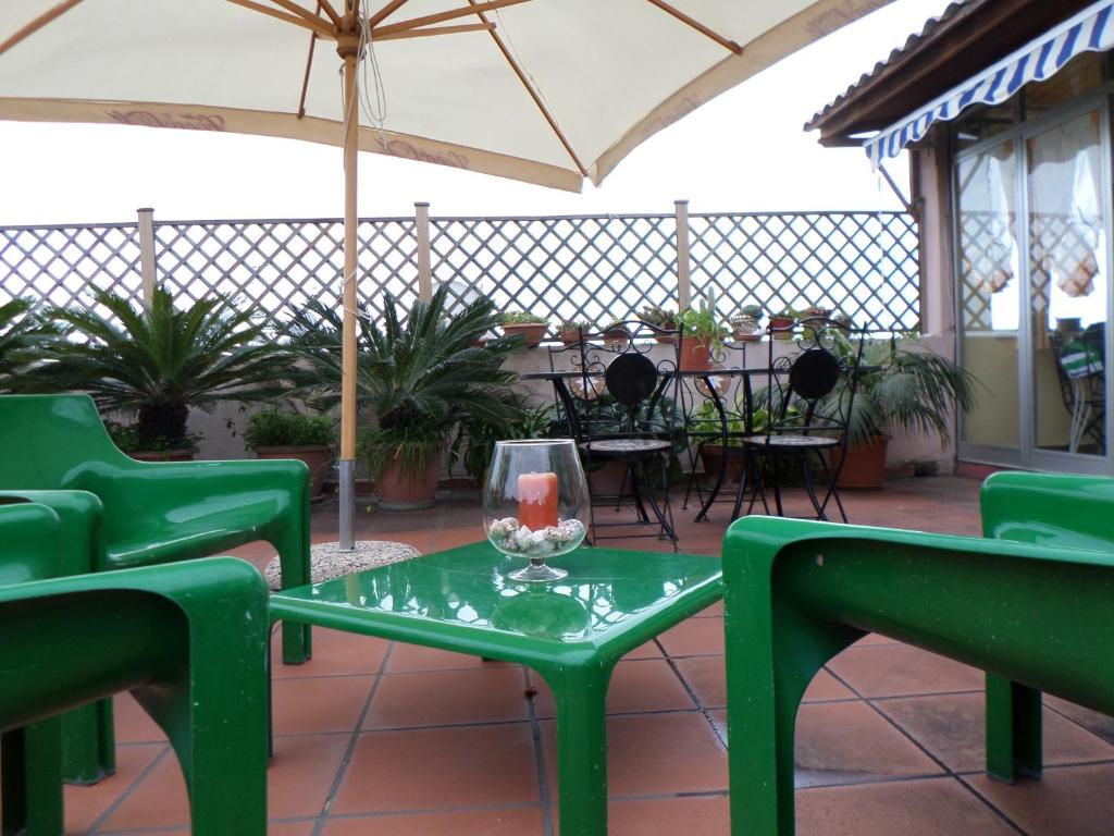 シャッカにあるCasa vacanze Sciaccaのパティオ(緑の椅子、テーブル、パラソル付)