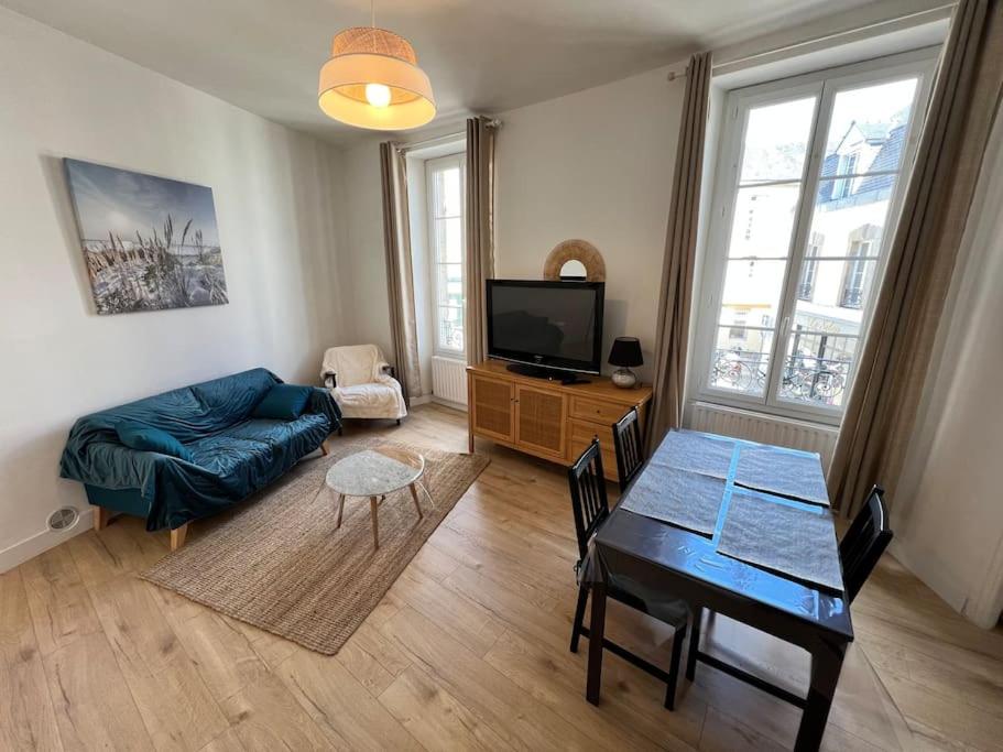 a living room with a blue couch and a table at Saint Goustan à pied! Joli appartement 2p in Auray