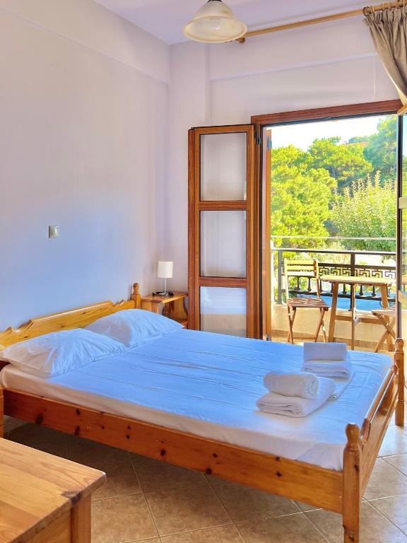 a bedroom with a bed and a large window at Marinos Studios and Apartments in Gialiskari