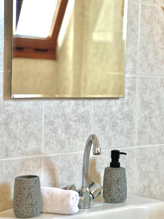 a bathroom sink with a faucet and a mirror at Marinos Studios and Apartments in Gialiskari