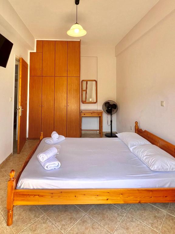 a bedroom with a bed with two towels on it at Marinos Studios and Apartments in Gialiskari