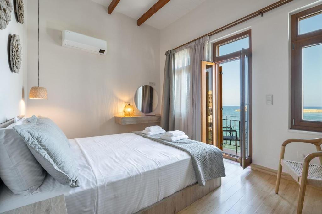 a bedroom with a bed with a view of the ocean at Leo Apartment 2 bdr apt overlooking the harbor in Chania