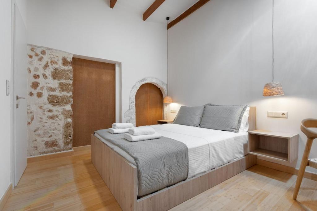 a bedroom with a large bed and a chair at Leo Apartment 2 bdr apt overlooking the harbor in Chania