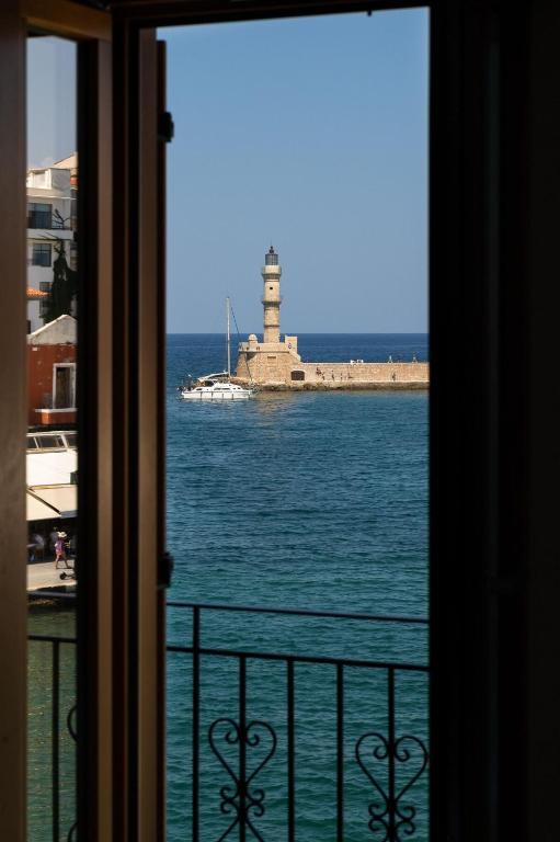 a view of a lighthouse from a window at Leo Apartment 2 bdr apt overlooking the harbor in Chania