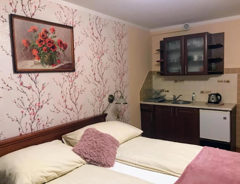 sypialnia z 2 łóżkami i kuchnia z kwiatami na ścianie w obiekcie Wynajem Pokoi Kasia i Józef Gałysa w Zakopanem