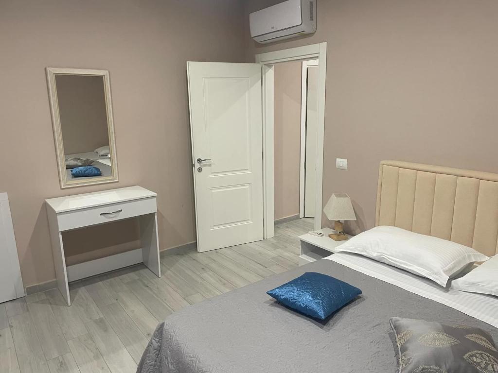 a bedroom with a bed and a desk and a mirror at Meri Hause in Vlorë