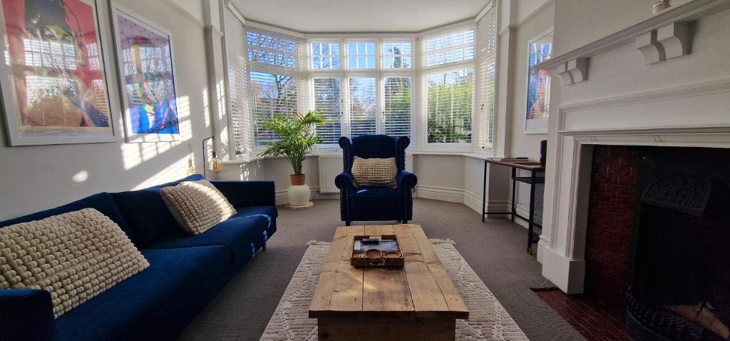 a living room with a blue couch and a fireplace at Woodfalls Luxury Getaway in Bournemouth