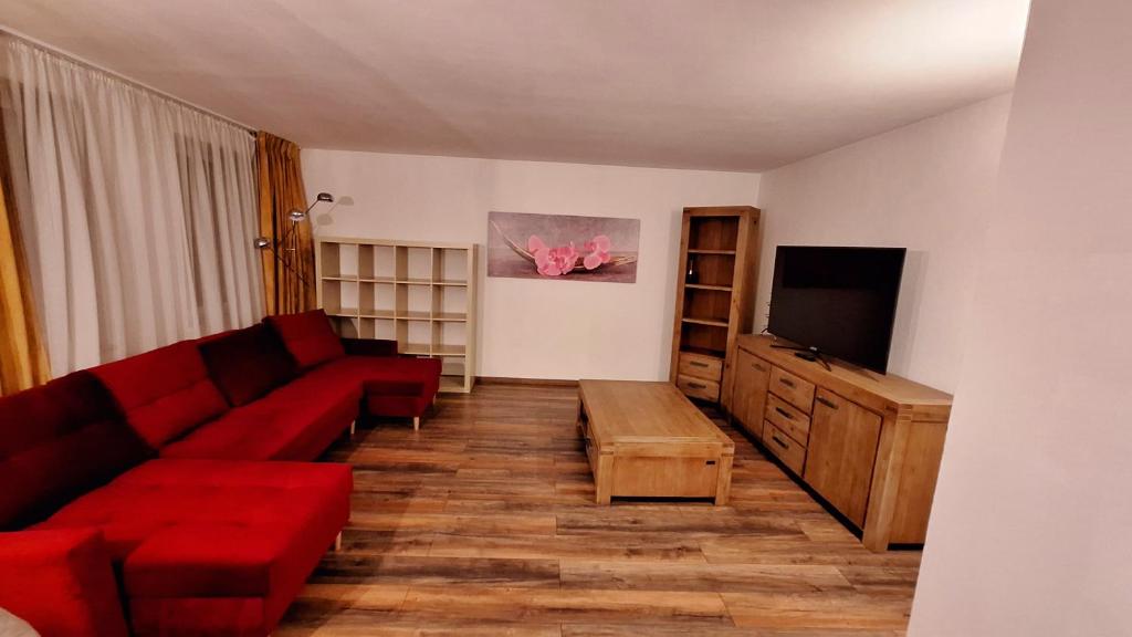 a living room with a red couch and a flat screen tv at Ferienwohnung in der Altstadt,3 in Annaberg-Buchholz