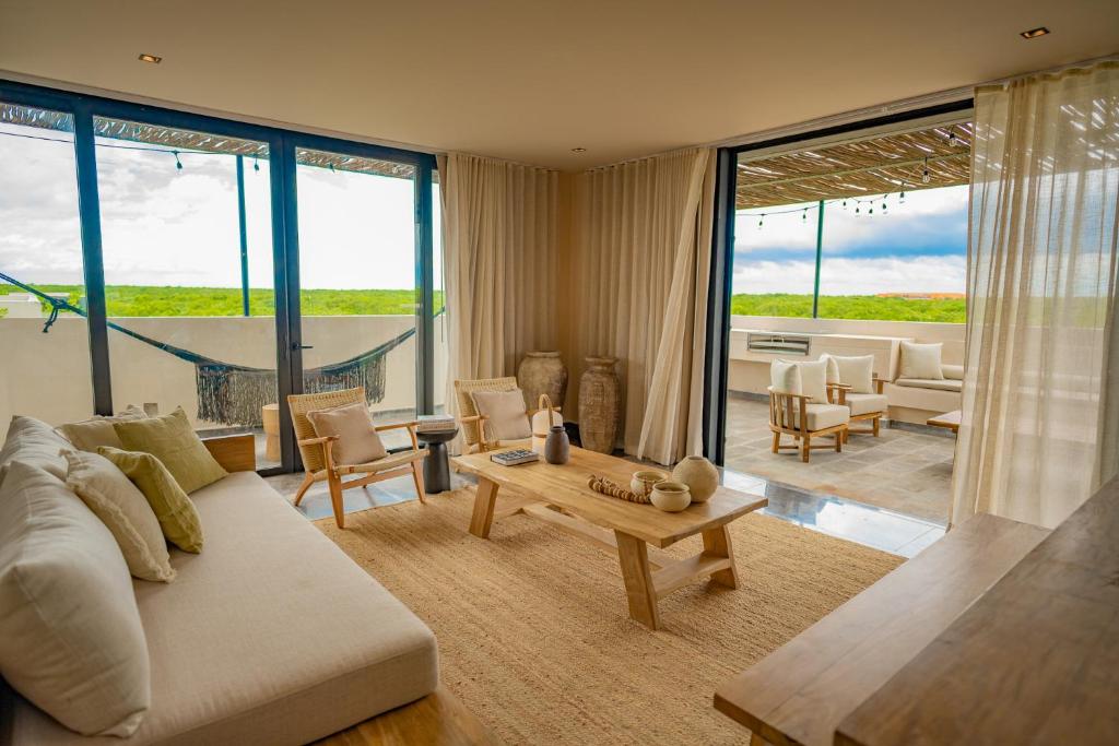 a living room with a couch and a table at Jungle Sunset Penthouse in Tulum with Private Pool, 5 Min from Beach in Tulum