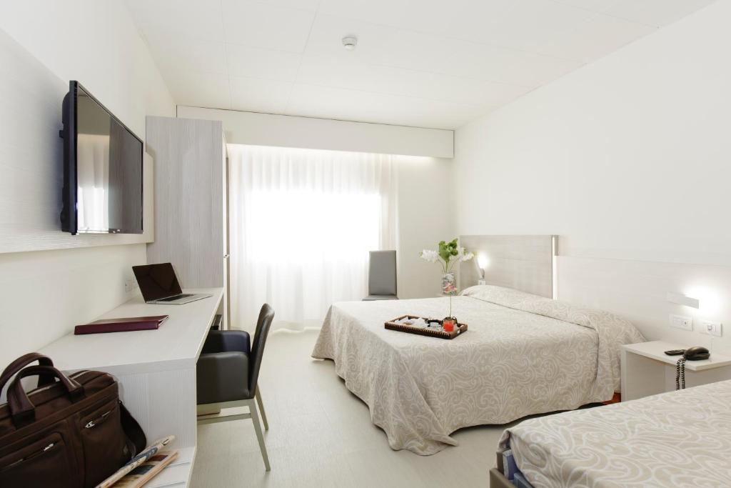 Postel nebo postele na pokoji v ubytování Alfa Fiera Hotel