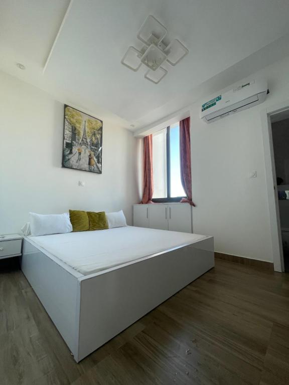 a white room with a large white bed in it at BBimmo APPART HOTEL in Dakar