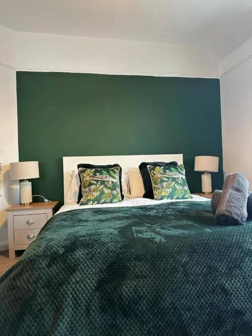 ウォリントンにあるSpacious 4Bedroom House in Warrington - Sleeps 8の緑の壁と大きなベッドのある寝室