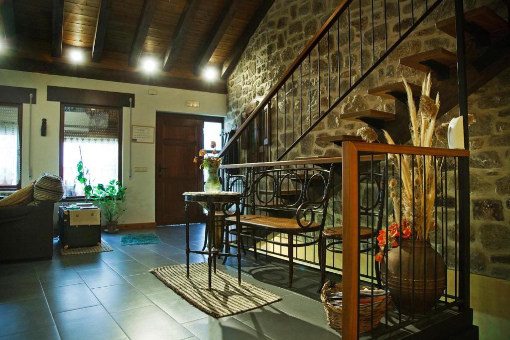 sala de estar con escalera y pared de piedra en El Rincón del Tarabilla, en Fermoselle