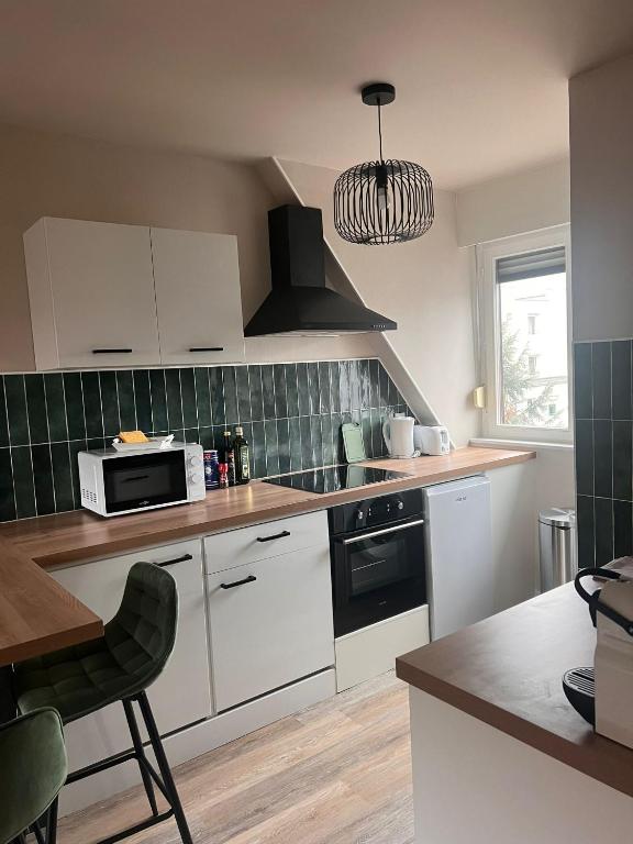 une cuisine avec des armoires blanches et un four à plaques de cuisson dans l'établissement NEW, Strasbourg T2 Neuf Proche Parlement, à Strasbourg