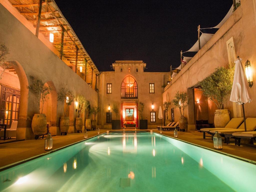 una piscina en un edificio por la noche en Caravan Serai en Douar Khalifa Ben Mbarek