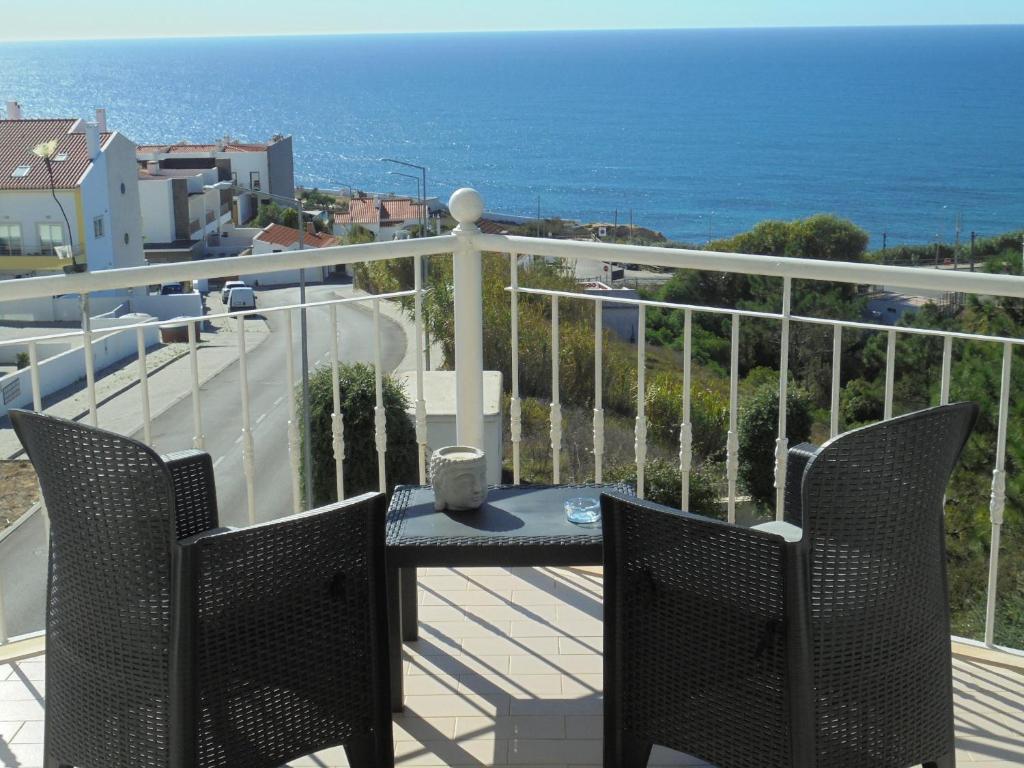 a balcony with a table and chairs and the ocean at Ericeira Sunset Apartment in Ericeira