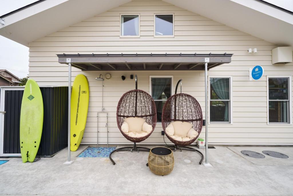 鴨川市にあるBungalow One - Vacation STAY 98273vの家の前の椅子2脚(サーフボード付)
