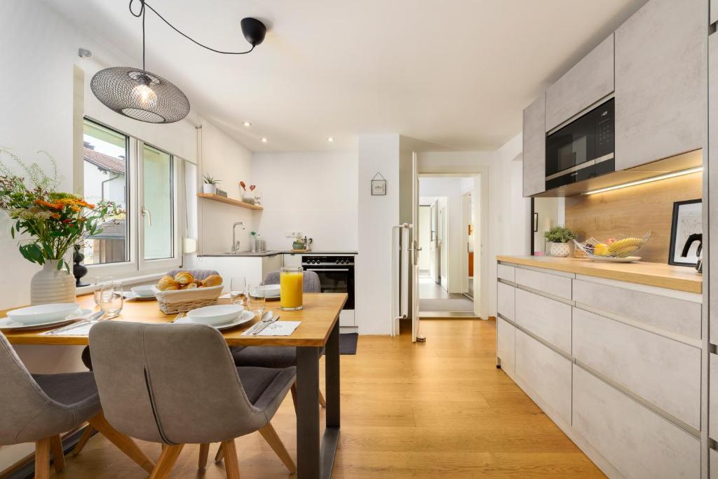 een keuken en eetkamer met een tafel en stoelen bij Bregenzer Traum am Bodensee inkl Fahrräder in Bregenz