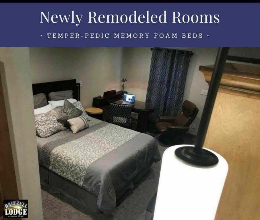 Un dormitorio con una cama y un escritorio con televisión. en Baltzell Lodge, en Great Bend