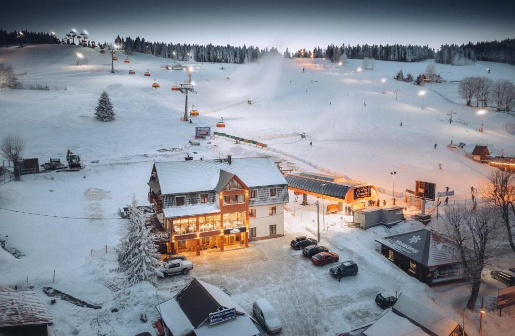 a ski lodge in the snow with a ski slope at Alpejski Zieleniec in Duszniki Zdrój