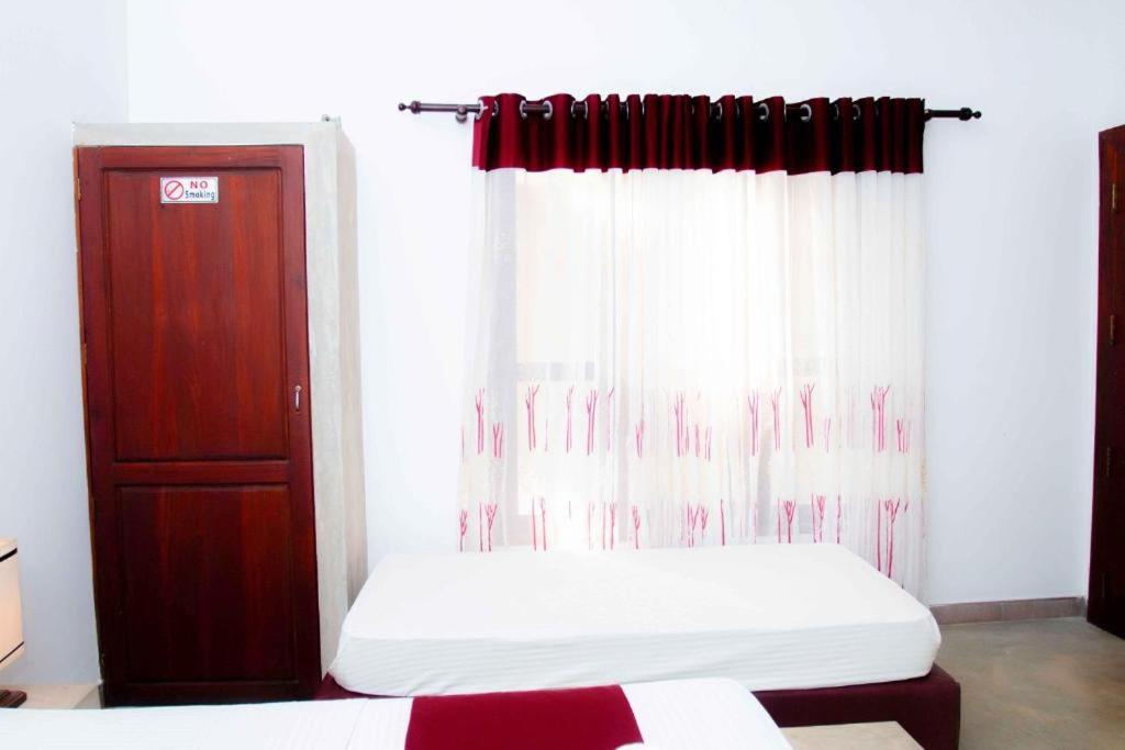 a bedroom with a bed and a window at Villa Manda Transit Home in Katunayake