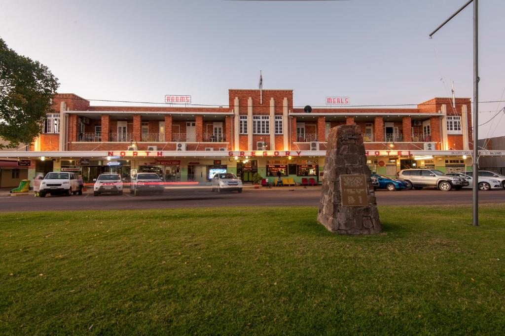 a stone sculpture in the grass in front of a building at North Gregory Hotel in Winton