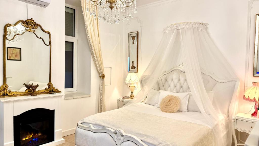 - une chambre blanche avec un lit à baldaquin et une cheminée dans l'établissement FSF Boutique Apartament, à Timişoara