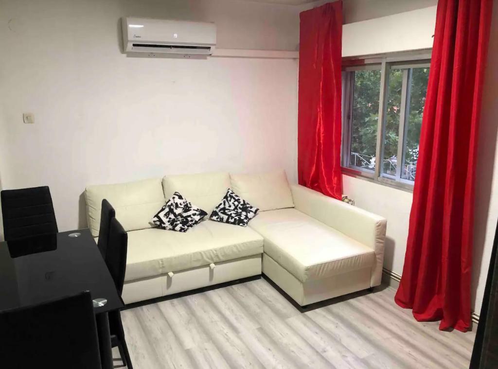 sala de estar con sofá blanco y cortinas rojas en Piso para Trabajo en goodella, en Madrid