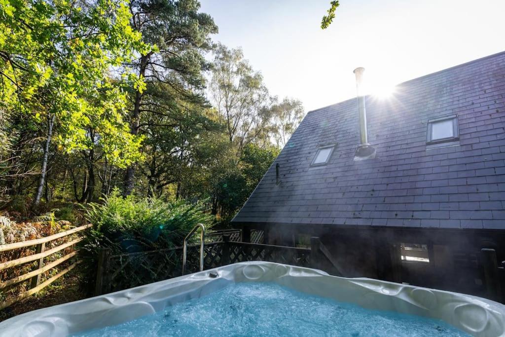 a hot tub in front of a house at Dimmingsdale, woodland lodge with hot tub for 8 in Oakamoor