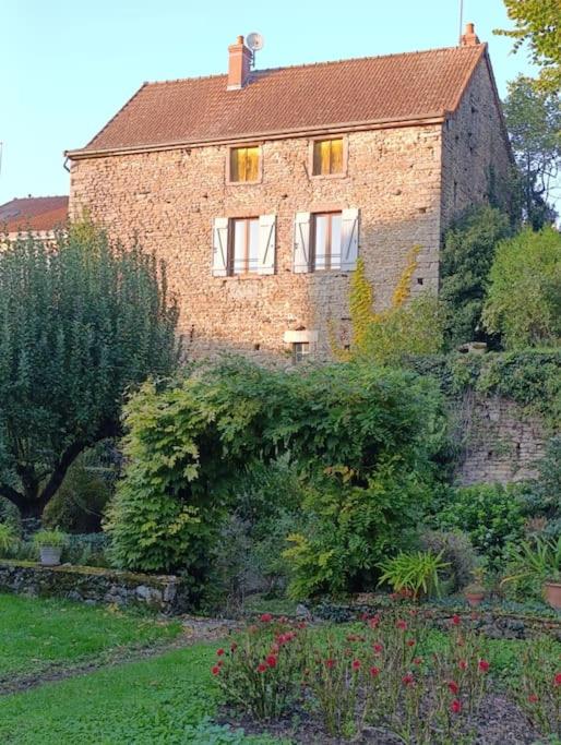 a large brick house with a garden in front of it at Le retour aux sources in Nolay