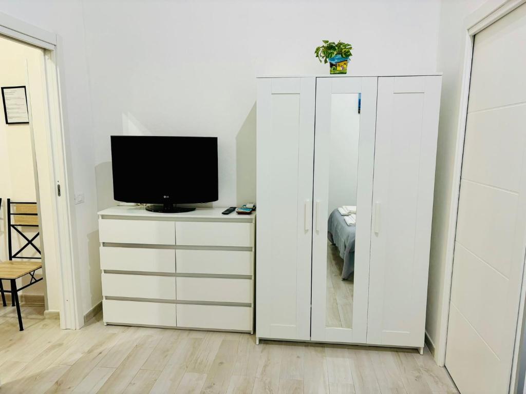 ein Wohnzimmer mit einem TV und einem weißen Schrank in der Unterkunft MaxMondello in Palermo