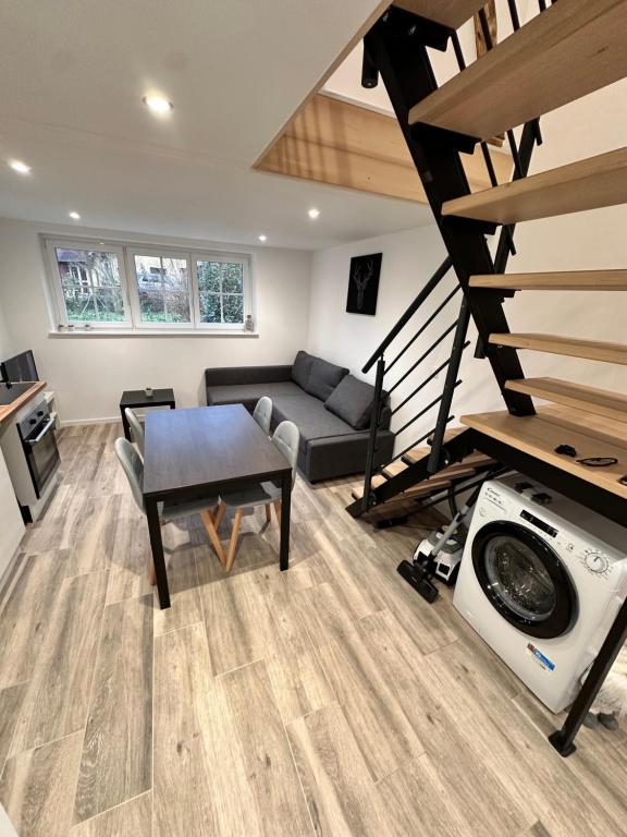 un soggiorno con un divano e una scala di Les grumeaux Colmar Est a Horbourg