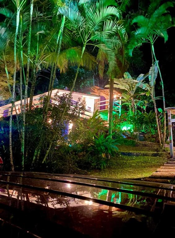 a park with palm trees and lights at night at BOSQUE TOQUE TOQUE Pousada in São Sebastião
