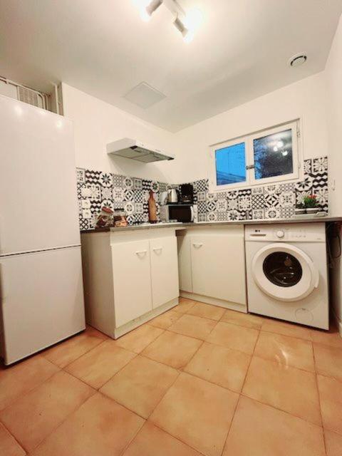 une cuisine avec un réfrigérateur et une machine à laver dans l'établissement Chalet, au Blanc-Mesnil