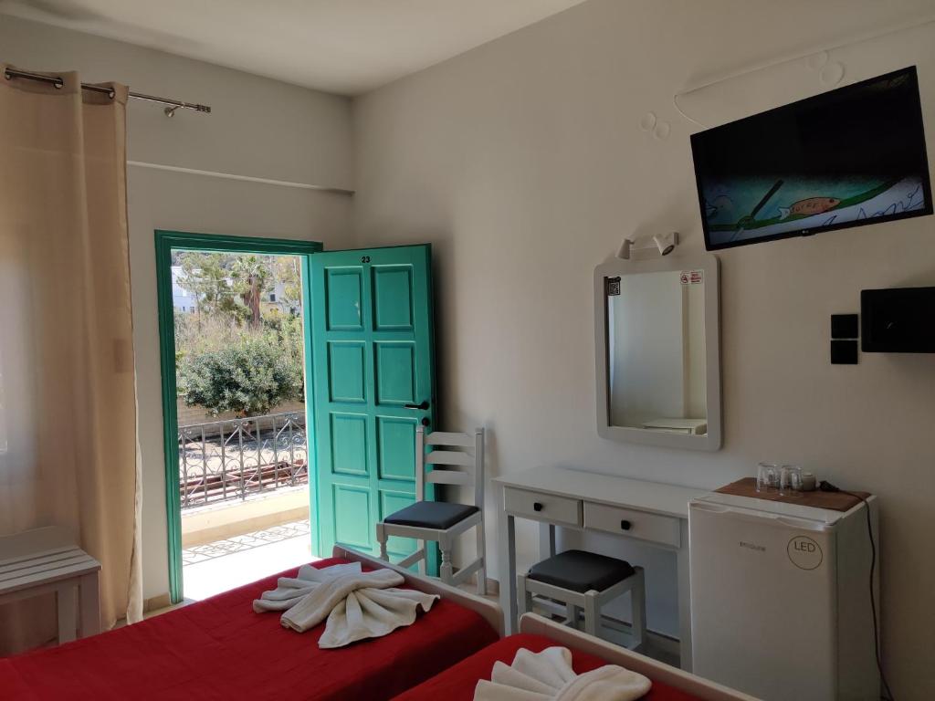 a bedroom with a bed and a desk and a mirror at Dimitris Villa Hotel in Matala