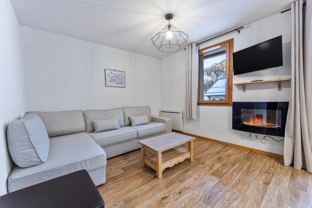 un salon avec un canapé et une cheminée dans l'établissement Les Chalets De Bois MÉan - A - Bel appartement rénové sur les Orres 1800 MAE-6581, aux Orres