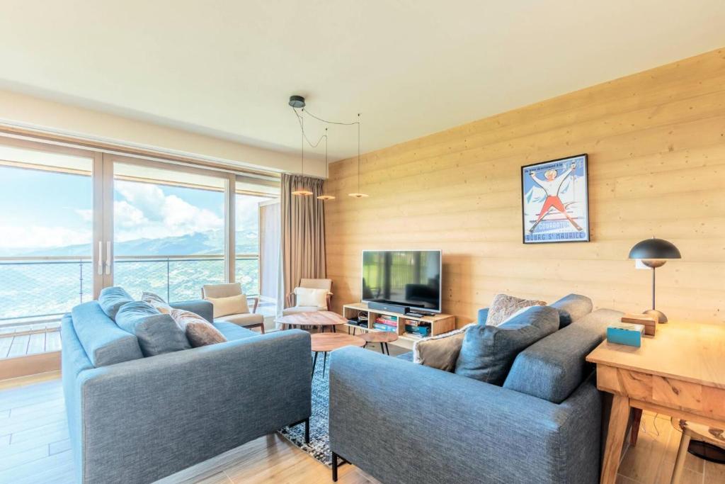 un salon avec deux canapés bleus et une télévision dans l'établissement Résidence Le Ridge - RIDGE 312 MAE-7761, à Arc 1600