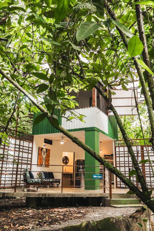 a green and white building with a bench in front of it at Peaceful Jungle Villa Kona - Pool & Parking for 2 persons in Puerto Viejo